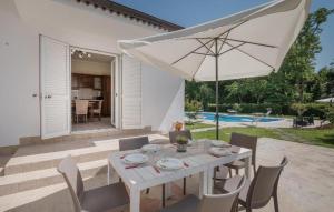 a white table with an umbrella on a patio at villa pia in Piumarola