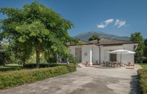 a white house with a tree and an umbrella at villa pia in Piumarola