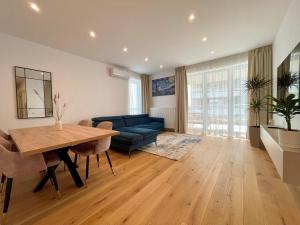 a living room with a table and a blue couch at Apartment No 401 Lebada Lake in Pantelimon
