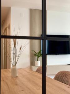 a vase on a wooden table in a room at Apartment No 401 Lebada Lake in Pantelimon