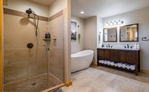 a bathroom with a shower and a tub and a sink at The Yellowstone - Spacious Wapiti Valley Cabin with Stunning Views! in Wapiti +38 photos