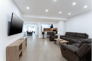 a living room with a couch and a flat screen tv at Apartman Svila in Đakovo