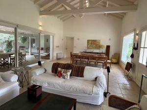 a living room with a couch and a dining room at Espectacular Casa en Barrio Privado El Faro, 5 suites independientes in Carmelo