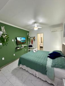 a bedroom with a bed and a flat screen tv at Flats Mirassol in Arraial do Cabo