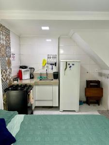 a small kitchen with a refrigerator and a sink at Flats Mirassol in Arraial do Cabo