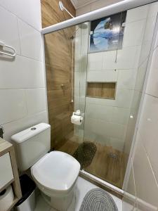 a bathroom with a toilet and a shower at Flats Mirassol in Arraial do Cabo