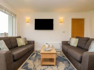 Una sala de estar con dos sofás y un televisor. en Juniper, en Truro