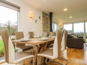 Un comedor con mesa y sillas de madera. en Juniper, en Truro