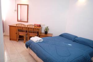 a bedroom with a bed and a table and a mirror at Inap Desa Chempaka, Golden Straits Villa in Port Dickson