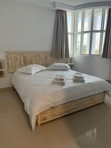 a bedroom with a large bed with two towels on it at Les persiennes usées in Sfax