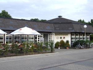 um restaurante com guarda-sóis em frente a um edifício em Boutique Hotel Wolfsburg em Wolfsburg