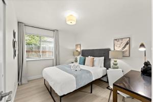 a bedroom with a bed and a desk and a window at Recently Upgraded House with King Suite, quiet NBHD, Fast Wifi, and Yard in Elk Grove
