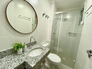 a bathroom with a sink and a mirror and a toilet at Residencial Acqua mare in Samaritá +17 photos