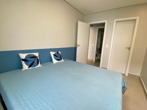a bedroom with a blue bed with two pillows at Residencial Acqua mare in Samaritá