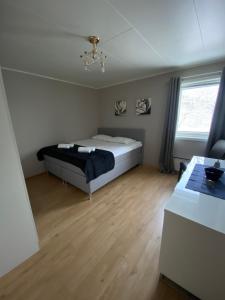 a bedroom with a bed and a wooden floor at Villa Valentina by Arctic Prive - Northern Lights Villa with Sauna & Fjord View in Alta in Alta