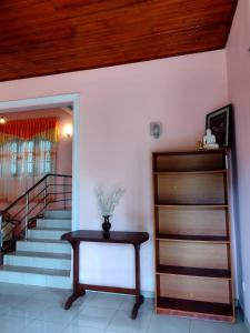 a room with a table and a stair case at Golden Glade in Weligama
