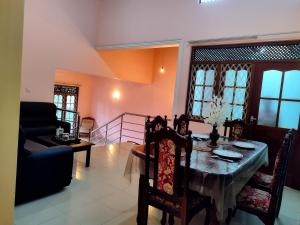 a dining room with a table and a couch at Golden Glade in Weligama