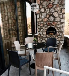a patio with a table and chairs and a fireplace at Umbrella Resort & Villas in Prishtinë