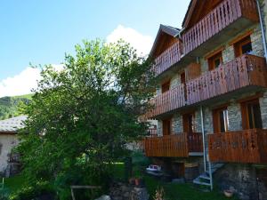 a building with wooden balconies and a tree at Chalet 5 pièces, 8 pers, au coeur de St Martin de Belleville, proche pistes et commodités - FR-1-452-65 in Saint-Martin-de-Belleville