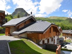 a large wooden building with a mountain in the background at Chalet confortable 10 pers. au centre de St Martin de Belleville, proche téléski et commodités - FR-1-452-67 in Saint-Martin-de-Belleville
