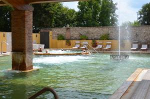 a swimming pool with a fountain in a yard at Parco Termale di Villa Dei Cedri in Lazise
