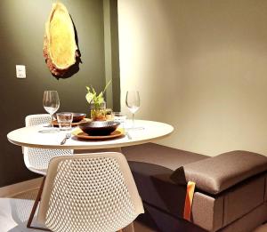 a table and chairs with wine glasses on it at Studio Incrível: Piscina, Wi-Fi, Pôr do Sol Mágico in Cabedelo