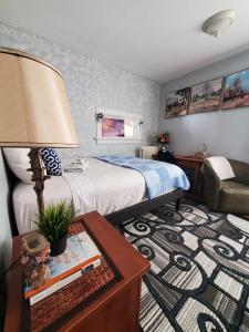 a bedroom with a bed and a table with a lamp at Merj's Guest House in Wolesly in Winnipeg