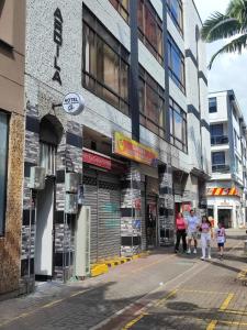a group of people walking in front of a building at La gran mansión en el centro de Pereira in Pereira +30 photos