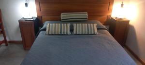 a bedroom with a bed with two pillows on it at Úrsula, MACONDO in Cañada de Gómez