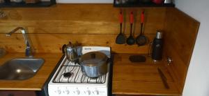 a kitchen counter with a stove with a pot on it at Úrsula, MACONDO in Cañada de Gómez