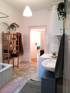 a bathroom with a sink and a bath tub at The Boho Hideaway in Leutsch in Leipzig