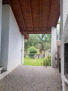 eine offene Veranda mit Holzdach und Blick auf einen Park in der Unterkunft Cabañas La Petunia in Santa Rosa de Calamuchita