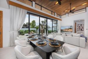 a dining room with a table and white chairs at Luxury 3BR Villa Eden with Private Pool by TropicLook in Ban Pak Lak