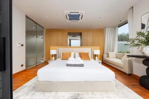 a bedroom with a large white bed and a couch at Luxury 3BR Villa Eden with Private Pool by TropicLook in Ban Pak Lak +49 photos