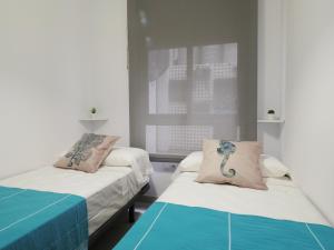 una stanza con due letti e una finestra di Apartamentos La Mar a 40 metros de la playa a El Campello Altre 62 foto