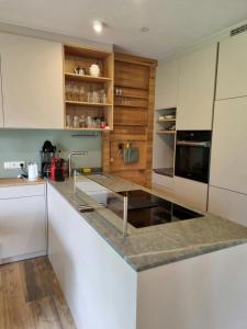 kuchnia z białymi szafkami i blatem w obiekcie Johanna 2 by SMR Rauris Apartments - inc Spa and near Gondola w mieście Rauris