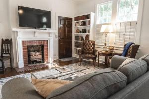 a living room with a couch and a fireplace at Historic Park Place Retreat - 3 Bdrm on the Park! in Columbus