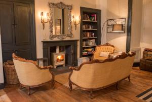 a living room with two chairs and a fireplace at Buccleuch Arms in Saint Boswells