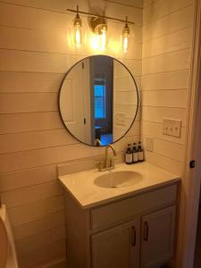 a bathroom with a sink and a mirror at Flat Fenced Yard, Hot Tub, Wifi, Pool Table in Sevierville