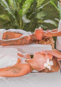 a woman laying on a bed with a flower on her face at Mirasurf Hotel & Waves in El Sunzal +23 photos