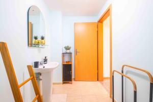 a bathroom with a sink and a yellow door at Santana House - Holiday Rental in Santana