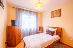 a bedroom with a bed and a dresser with a television at Santana House - Holiday Rental in Santana +10 photos