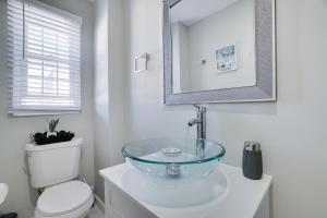 a bathroom with a glass bowl sink next to a toilet at Beautiful 2BR Home Near Penn Station in Newark