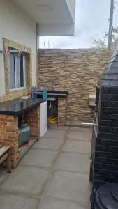 ペルイベにあるKitnets Peruíbe casa 02のカウンターとレンガの壁のあるパティオ