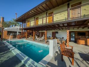 a house with a swimming pool and a balcony at Pousada Recanto Dourado in Bonito