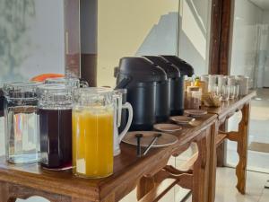 a wooden table with glasses of orange juice on it at Pousada Recanto Dourado in Bonito