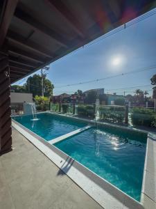 a swimming pool with blue water in a yard at Pousada Recanto Dourado in Bonito
