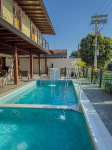 a swimming pool with a water fountain in a house at Pousada Recanto Dourado in Bonito