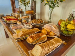 a table topped with lots of bread and other foods at Pousada Recanto Dourado in Bonito