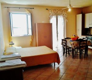 ポルト・エンペードクレにあるAppartamento Sergioのベッドルーム1室(ベッド1台、テーブル付)、キッチン